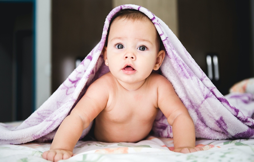 baby under purple blanket